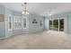 Spacious living room features a fan, a chandelier, multiple windows, and a sliding door to the balcony at 1529 Lanterns Rest Dr. # 201, Myrtle Beach, SC 29579