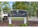 Entrance sign for Riverwalk with lush green landscaping and American flags at 1529 Lanterns Rest Dr. # 201, Myrtle Beach, SC 29579