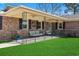 Brick front home boasts a covered porch with comfortable seating and a well-manicured lawn at 1586 Bridgebrook Ln., Conway, SC 29527