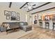 Spacious living room featuring wood floors, a gray sofa, and views to the kitchen bar at 1586 Bridgebrook Ln., Conway, SC 29527