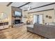 Cozy living room with brick fireplace, wood floors, ceiling beams, and natural light at 1586 Bridgebrook Ln., Conway, SC 29527