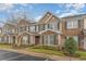 Brick townhome showcasing lush landscaping, green shutters, and neutral siding accents at 159 Chenoa Dr. # E, Murrells Inlet, SC 29576