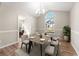 Formal dining room with modern chandelier, large arched window, seating for six, and neutral decor at 1639 Coventry Rd., Surfside Beach, SC 29575