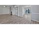 Open living room with fireplace, high ceilings, wood-look vinyl floors, and an open doorway at 1639 Coventry Rd., Surfside Beach, SC 29575