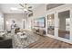 Open-concept living room with neutral tones, large windows, french doors, and decorative geometric rug at 1639 Coventry Rd., Surfside Beach, SC 29575
