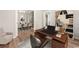 Home office area with wood desk, chair, shelving, and view into the dining room through an open doorway at 1639 Coventry Rd., Surfside Beach, SC 29575