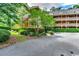 Exterior view of condominiums with balconies, surrounded by green landscaping and a parking area at 180 Rothbury Circle # 303, Myrtle Beach, SC 29572