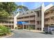 Condo building with layered decks, lush landscaping, a covered entrance, and a neatly paved driveway at 180 Rothbury Circle # 303, Myrtle Beach, SC 29572