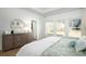 Bright bedroom features white walls, light wood floors, a large dresser, and a triple window overlooking a lush outdoor area at 1808 Sunshine Ct., North Myrtle Beach, SC 29582