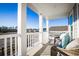 Inviting porch with comfortable wicker seating, white railing, columns, and a serene neighborhood view at 1808 Sunshine Ct., North Myrtle Beach, SC 29582