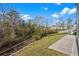 Sloped backyard with a concrete walkway and metal railing, transitioning to a natural wooded area at 188 Timber Oaks Dr., Myrtle Beach, SC 29588