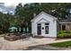 Exterior view of a white building with patio seating and green umbrellas, surrounded by lush landscaping at 2264 Wedgefield Rd., Georgetown, SC 29440