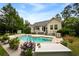 Beautiful backyard featuring a sparkling in-ground pool surrounded by lush greenery and a charming patio area at 2264 Wedgefield Rd., Georgetown, SC 29440