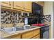 A well-equipped kitchen featuring black appliances, wooden cabinets, and tile backsplash at 2311 S Ocean Blvd. # 969, Myrtle Beach, SC 29577