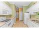 Clean kitchen featuring white cabinets, laminate countertops, white appliances, and tile floors at 25 Berwick Dr., Pawleys Island, SC 29585