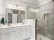 Modern bathroom featuring double sinks, a glass shower, and neutral tile at 301 Lumbee Circle, Pawleys Island, SC 29585