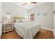 Bright bedroom with a queen bed, side tables, ceiling fan, and wood-look flooring at 301 Lumbee Circle, Pawleys Island, SC 29585