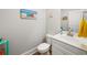 Clean powder room with a white vanity, toilet, and beach-themed decor at 301 Lumbee Circle, Pawleys Island, SC 29585