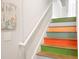 Fun stairway with brightly painted treads and white risers, adorned with decorative wall art at 301 Lumbee Circle, Pawleys Island, SC 29585