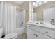 Bright bathroom featuring a shower with white shower curtain, and a white vanity with ample storage at 3369 Collins Creek Dr., Murrells Inlet, SC 29576