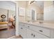 Bright bathroom with double sinks, white cabinetry, and a view into the adjacent bedroom at 3369 Collins Creek Dr., Murrells Inlet, SC 29576