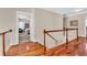 Hallway with hardwood floors, a wooden railing, and views into adjacent rooms at 3369 Collins Creek Dr., Murrells Inlet, SC 29576