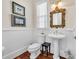 Stylish powder room with a pedestal sink, framed mirror, and hardwood floors at 3369 Collins Creek Dr., Murrells Inlet, SC 29576