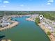 Aerial view of a lakeside residential area with well-manicured lawns and community amenities at 356 Carriage Lake Dr., Little River, SC 29566