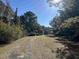 A gravel driveway leading to a secluded homesite surrounded by mature trees at 402 Wilkinson St., Georgetown, SC 29440