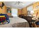 Cluttered bedroom with wood paneled walls, ceiling fan, and window with blinds at 408 Sunset Trail, Myrtle Beach, SC 29577