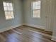 Bright bedroom with two windows, light gray walls, white trim, and wood-look flooring at 415 Circle Dr., Johnsonville, SC 29555