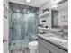 Modern bathroom featuring a glass enclosed tile shower, marble countertop, and decorative shelving at 423 Parker Dr. # 306, Pawleys Island, SC 29585