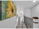 Bright hallway features hardwood floors, fresh white walls, eye-catching sunflower artwork, and ornate wrought iron railing at 423 Parker Dr. # 306, Pawleys Island, SC 29585