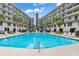 Community pool with clear blue water surrounded by lounge chairs and palm trees at 423 Parker Dr. # 306, Pawleys Island, SC 29585