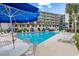 Resort pool surrounded by lounge chairs and blue umbrellas at 423 Parker Dr. # 306, Pawleys Island, SC 29585