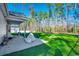 Green backyard featuring a covered patio area, a large lawn, and mature trees providing privacy at 477 Cane Branch Rd., Loris, SC 29569