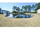 Scenic view of a community pond surrounded by lush greenery and residential buildings under a clear blue sky at 4935 Crab Pond Ct. # 203, Myrtle Beach, SC 29579