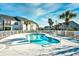 Kidney shaped community pool with a fenced-in area surrounded by palm trees at 4935 Crab Pond Ct. # 203, Myrtle Beach, SC 29579