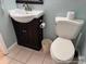 Powder room including dark wood cabinet, sink, and a white toilet at 5511 N Ocean Blvd. # 1006, Myrtle Beach, SC 29577