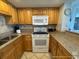 Kitchen featuring granite counters, oven, and wooden cabinets at 5511 N Ocean Blvd. # 1006, Myrtle Beach, SC 29577