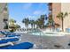 Exterior shot of the pool with plenty of lounge chairs, palm trees and beach views at 5511 N Ocean Blvd. # 1006, Myrtle Beach, SC 29577