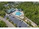 Community pool with a playground and a large parking lot surrounded by many trees at 5719 Whistling Duck Dr., North Myrtle Beach, SC 29582