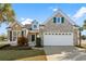 Charming brick home with a two-car garage and a well-manicured lawn featuring a white picket fence at 5719 Whistling Duck Dr., North Myrtle Beach, SC 29582