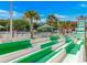 Fun waterslide at a community pool area, featuring green and white stripes, palm trees, and lounge seating at 6001-1723 South Kings Hwy., Myrtle Beach, SC 29575