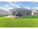 View of the backyard, featuring green grass, a small patio with a covered area, grill, and air conditioning unit at 616 Choctaw Dr., Conway, SC 29526