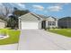 Exterior view of a one-story home featuring a wide driveway, attached two-car garage, and manicured lawn at 616 Choctaw Dr., Conway, SC 29526