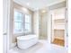 Luxurious bathroom with soaking tub, marble tile, and walk-in shower, next to a closet at 641 Waterbridge Blvd., Myrtle Beach, SC 29579
