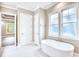 Bright bathroom featuring a soaking tub, two windows, and a doorway leading to the bedroom at 641 Waterbridge Blvd., Myrtle Beach, SC 29579