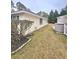 Side view of the exterior with a well-maintained lawn, storage bin, and vinyl siding at 6512 Laguna Point, Myrtle Beach, SC 29588