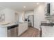 Modern kitchen with stainless steel appliances, granite countertops, white cabinetry and wood-look flooring at 692 Wallace Dr., Little River, SC 29566